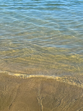 Gentle sea waves on the sandy beach vertical