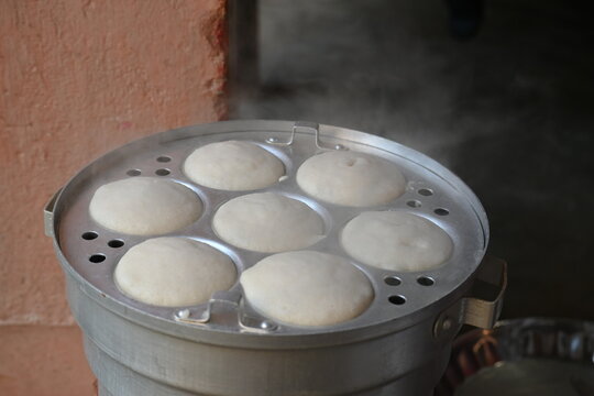 Soft steamed idlis are being prepared in the steamer and. Idli is a popular South Indian breakfast made from a fermented batter of rice and urad dal. Steamed to soft perfection, it is healthy.