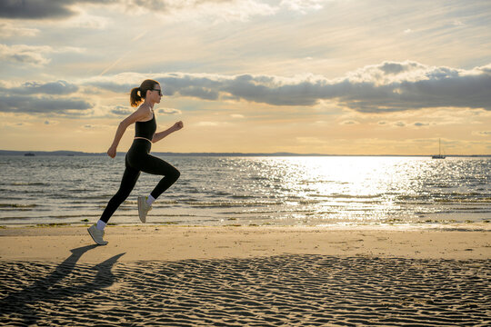 Woman Running on Beach at Sunset