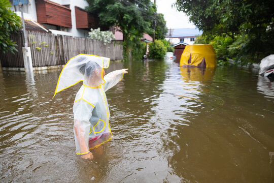 boy pointing at car that flooded in bangkok thailand, lifestyle of Thai people in massive flooding, Severe weather. 2026/09/27
