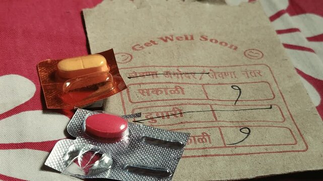 Prescribed Medication Regimen for Flu Recovery: An open blister pack of cold tablets rests on a handwritten Marathi medical envelope with morning and night dosage markings for home treatment.