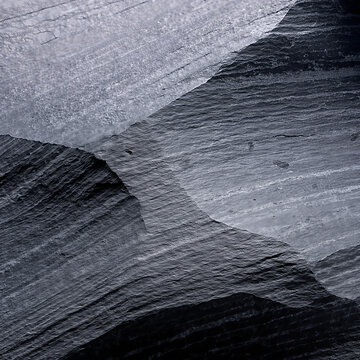A close up view of dark layered slate stone surface with natural textured rock ridges