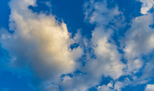 Soft clouds drift above deep blue sky