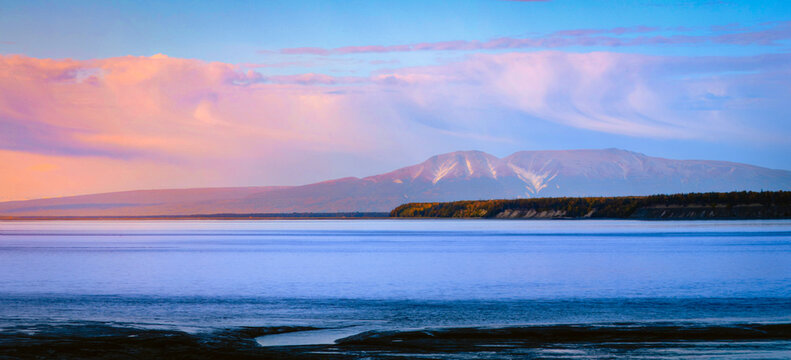 Alaska Anchorage seascape at Cook Inlet at low tide with view of mountains and cloudscape at sunset in USA.