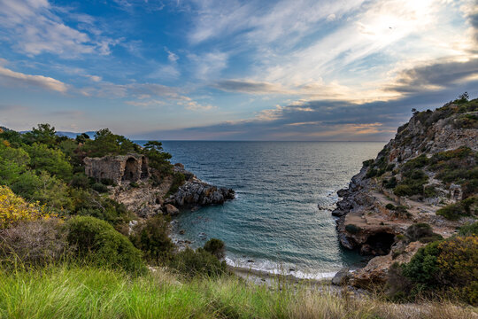 Calm sea meets rugged cliffs at golden hour
