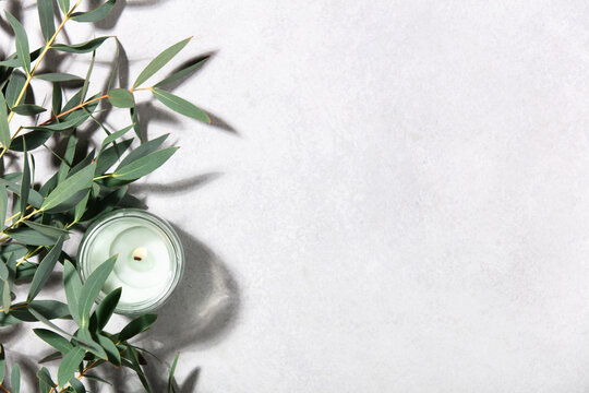 Eucalyptus Leaves and Scented Candle on Minimal Light Background