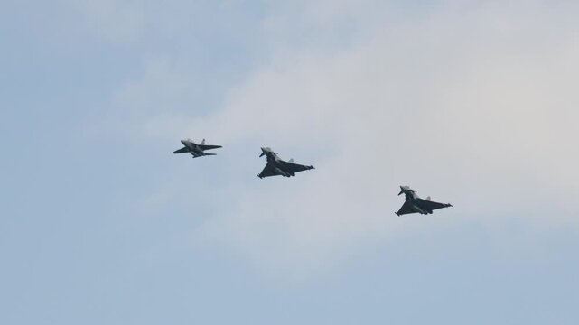 Military fighter jets performing aerial maneuvers in formation