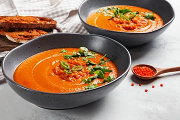 Red lentil soup in gray bowl with toasted bread, side view © Diana Vyshniakova
