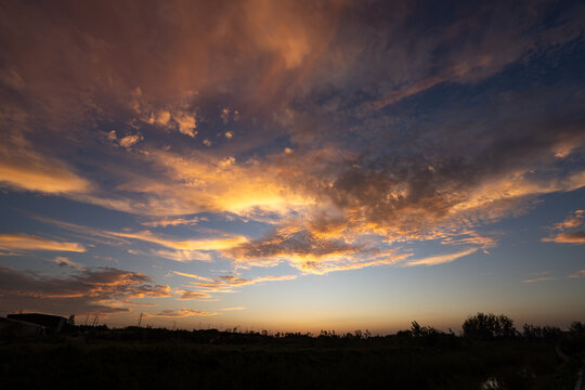 dramatic sunset sky with colorful clouds over field