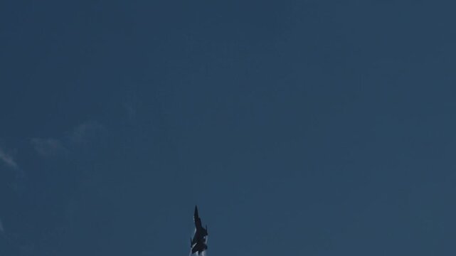 Military F16 fighter jet climbing into the sky