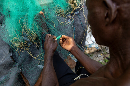 Man repairing a fishing net, Cape Coast, Ghana