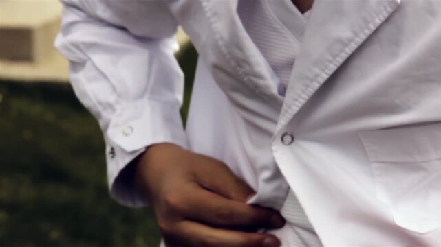 Close Up of Argentine Primary School Student Buttoning White Apron Uniform - 4K