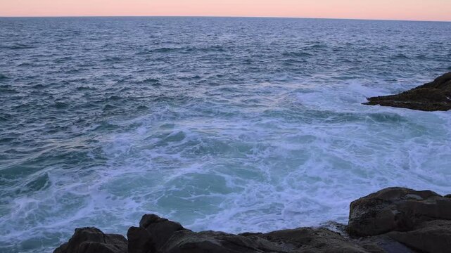 Florianopolis-SC-Brazil-Golden sunset over the ocean with powerful waves breaking against coastal rocks
Seascape at sunset with sea waves crashing on rocky shore under a golden sky