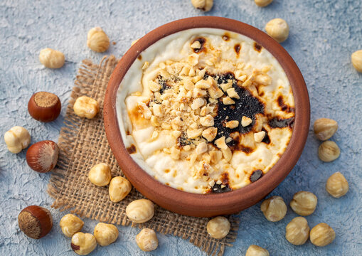 Baked rice pudding turkish milky dessert sutlac in earthenware casserole with hazelnuts