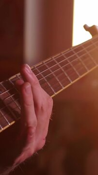 Detailed macro shot of a guitarist's hands pressing strings and frets on an acoustic guitar neck during a warm session.
