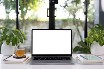 Obraz premium Laptop and a glass of tea and notebook, cozy indoor workspace