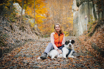 Obraz premium happy white dog with owner in autumn forest