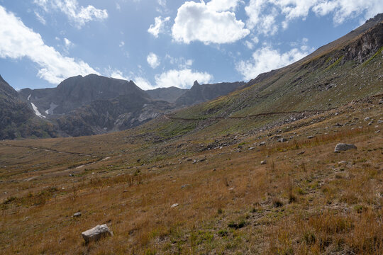 Dramatic Rocky Mountain Valley with Hiking Trail and Jagged Cliffs.