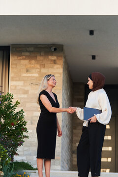 Professional Business Handshake Between Two Women Outside Modern Home During Real Estate Meeting