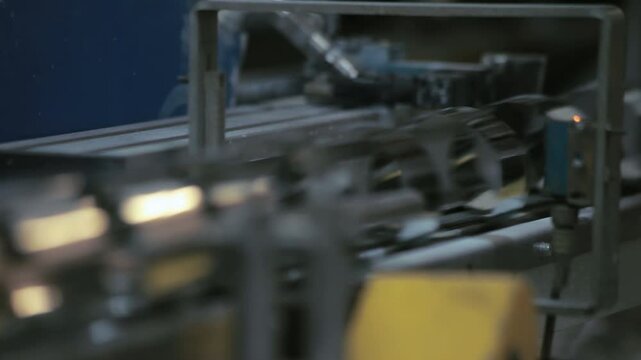 Closeup automated production line sensor. Industrial conveyor machine factory.