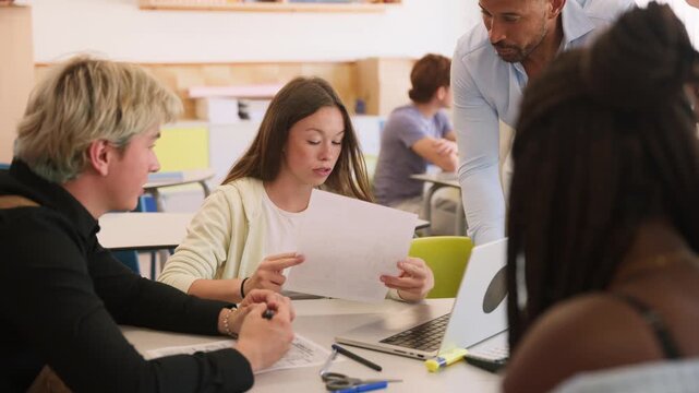 Teacher helping students with a collaborative project in the classroom