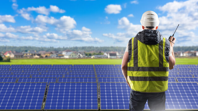 Solar energy, photovoltaic power plant engineer monitors solar panels and communicates by radio during inspection and maintenance of renewable energy equipment.