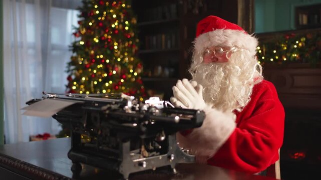 Merry Christmas. Santa mail. Happy Santa typing tact on typewriter for New Year Christmas in festive living room. Santa typing letter on Christmas eve. Mail of Santa Claus. Winter Holiday Celebrations