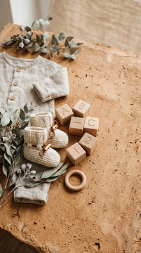Woolen baby shoes and onesie in modern commercial stock setting
