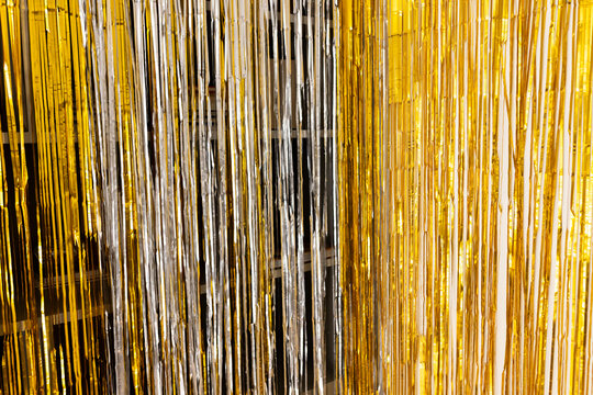 Metallic fringe curtain is shimmering with gold and silver streamers as party backdrop