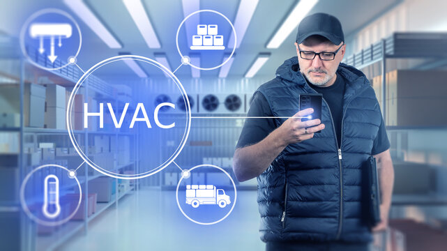 Cold storage warehouse, manager uses a smartphone to remotely monitor HVAC systems, control temperature and manage refrigeration for food storage and logistics.