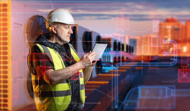 Industrial HVAC, engineer uses a tablet to inspect rooftop air conditioning units, monitor ventilation equipment and control building cooling systems remotely.