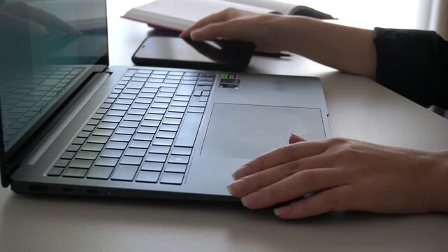 Hands typing on modern laptop keyboard for office work and coding