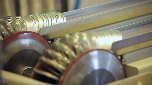 Golden metal jar lids moving conveyor. Close up food factory production line.