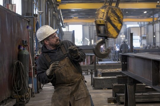 Metalworker Losing Balance Near Overhead Crane Load