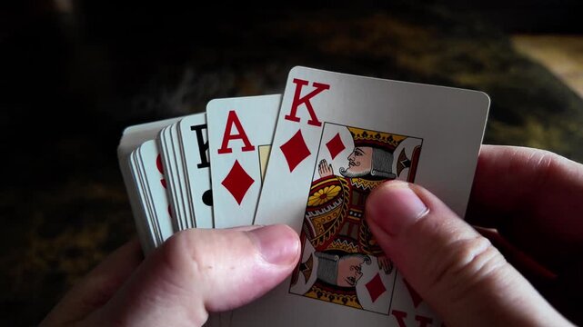 Hands holding playing cards with king and ace