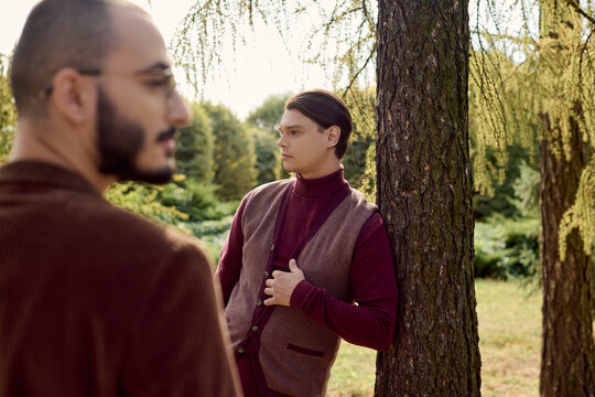 Stylish young men celebrate autumn fashion in a vibrant forest setting