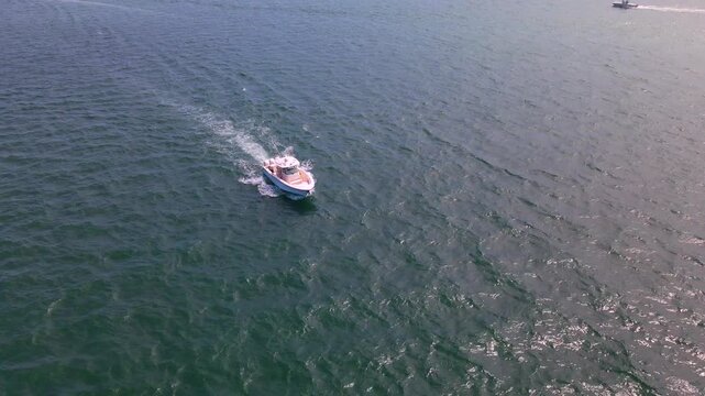 Motorboat passes across sparkling North Carolina water while the camera moves closer.
