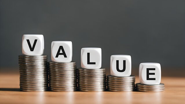 Value spelled with white dice on top of decreasing stacks of shiny silver coins representing financial depreciation market loss wealth reduction and economic drop