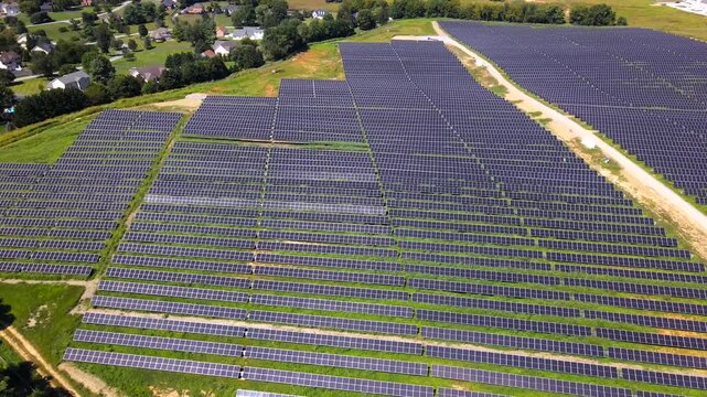 Parallel solar panels create geometric patterns across Virginia land in 4K video.
