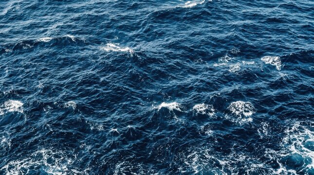 Deep blue sea water with small waves and white foam