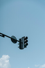 Traffic light mounted on a metal pole against a clear blue sky © uladzimirzuyeu