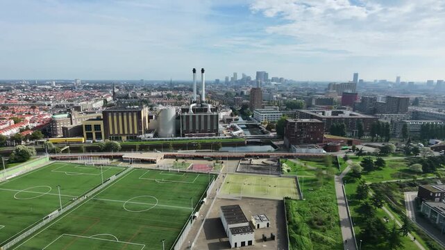 Drone view of The Hague city skyline with power station and sports fields in foreground