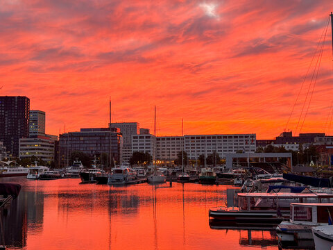 Vibrant red sunset over marina with yachts and city skyline in Antwerpen, Belgi&euml;