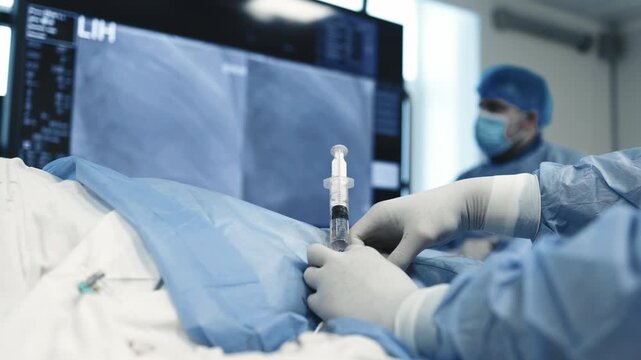 Close-up of fluid injection through a catheter during an interventional procedure under angiography guidance.