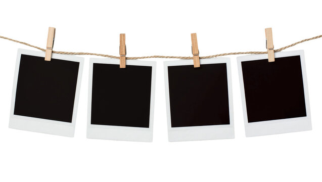 Four blank instant photo prints with black centers clipped by wooden pegs on a twine string, isolated on transparent background