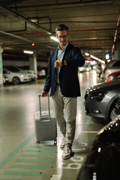 Business traveler checking time walking in parking garage