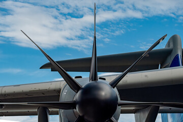 Closeup of turboprop engine and multi blade propeller on aircraft wing under blue sky with clouds for aviation engineering sectors © Val MAK