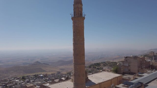 Ulu Cami minaret in Mardin, Turkey, the Great Mosque of Mardin seen from above with flat old town roofs and the Mesopotamian plain beyond