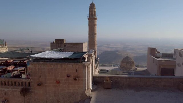 Great Mosque of Mardin minaret, Ulu Cami, Turkey, and a ribbed stone dome above rooftop terraces, overlooking the hazy Mesopotamian plain