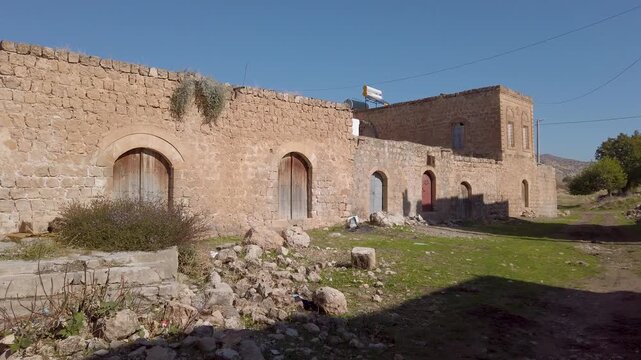 Dereici, also known as Killit, a Syriac village near Savur, Mardin, Turkey, old stone house with arched wooden doors and rubble in front